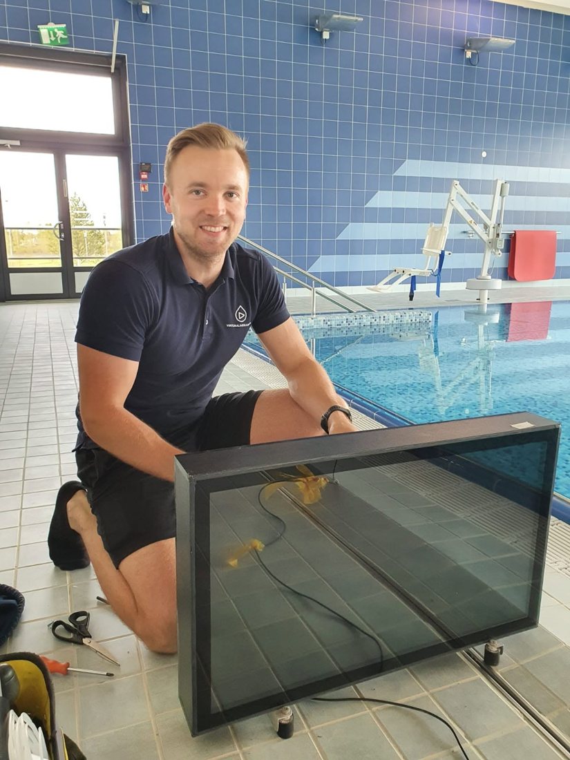 Waterbic team member with a screen at the edge of a swimming pool